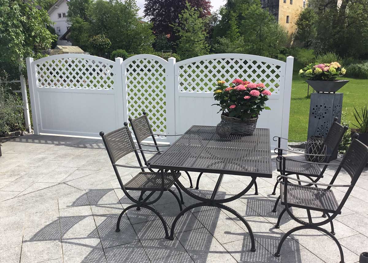 weißer Sichtschutz aus Kunststoff mit Rankgitter zur Terrassenbegrenzung