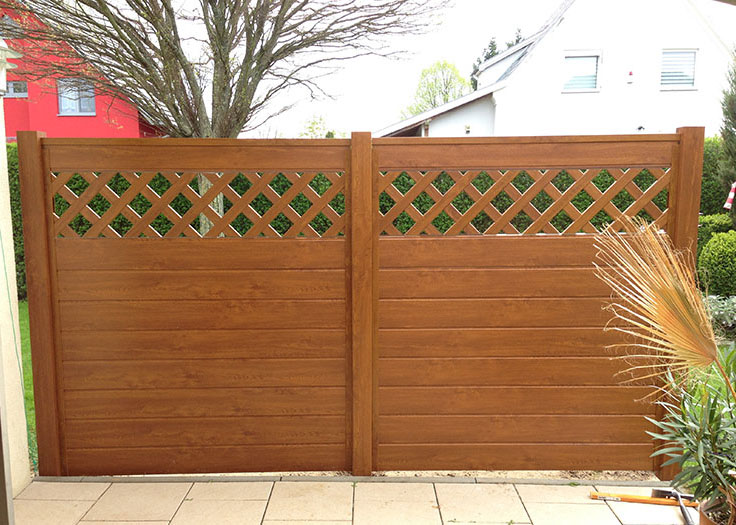 Sichtschutz aus Kunststoff PVC in Holzoptik Golden Oak zwischen Mauern Steinsäulen im Garten