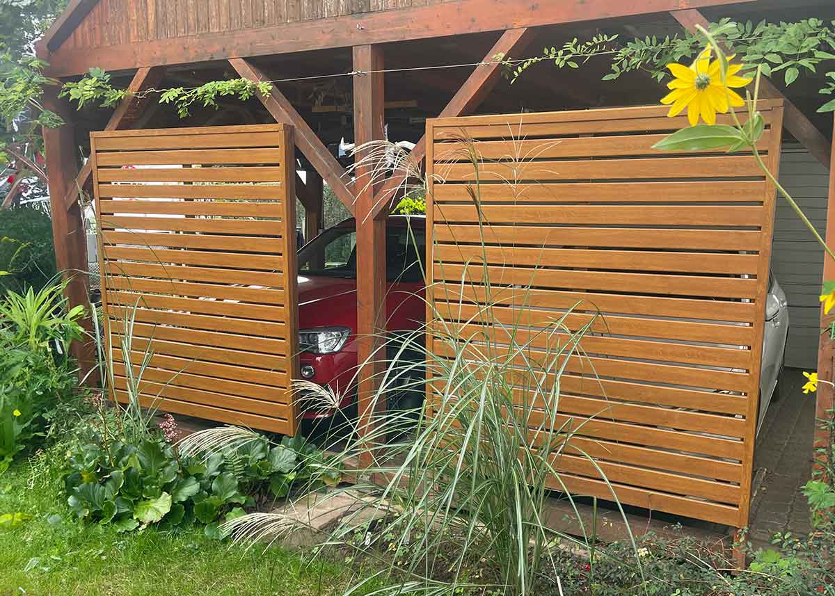holzfarbene Trennwand im Garten mit Spaltelementen aus hochwertigen PVC