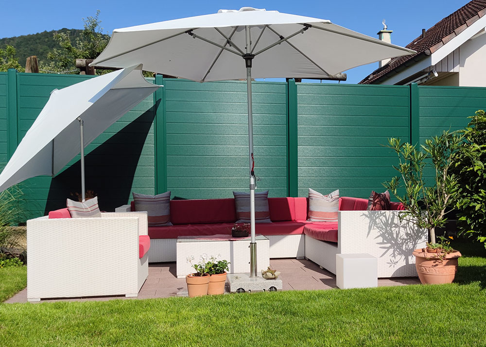 Kunststoff Dichtzaun im Garten, grüne Wand aus PVC in einer Sitzeke