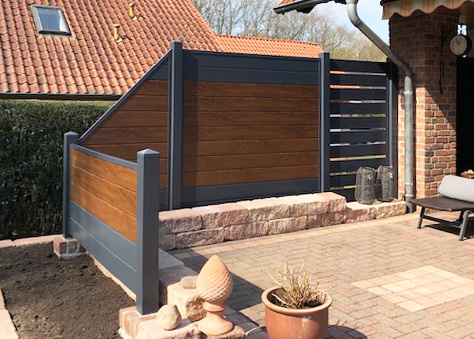 Ecoline pflegeleichter Dichtzaun in Golden Oak und Anthrazit auf einer Terrasse, kein WPC