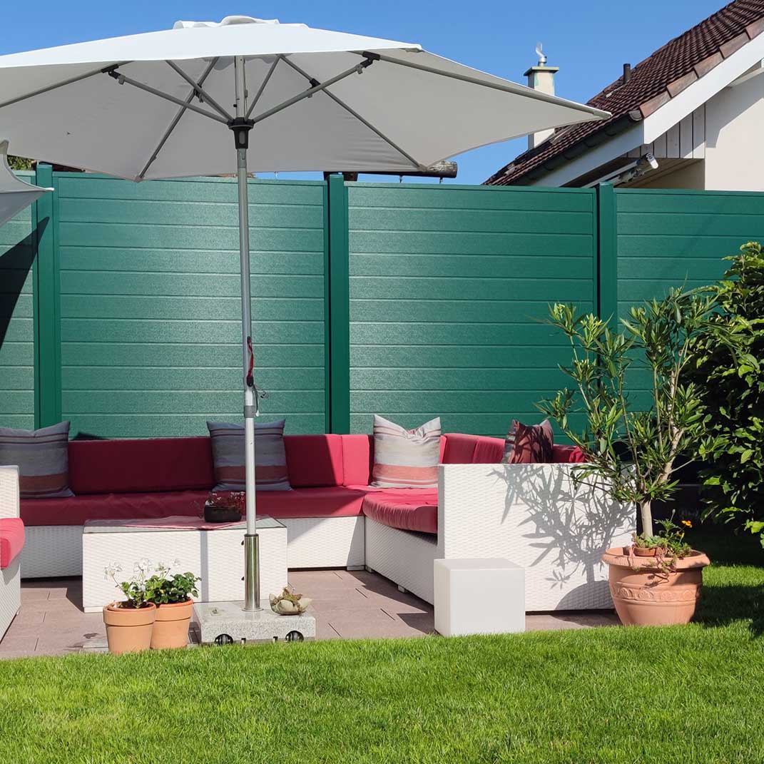 ECOLINE - eine grüne Sichtschutzwand ist pflegeleicht, natürlich und ersetzt eine aufwendige Heckenbepflanzung Sichtschutzzaun aus Kunststoff in Moosgrün im Garten an einer Terrasse, grüne Wand