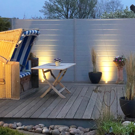 Sichtschutz in Grau auf einer Holzdeckterrasse im Abend