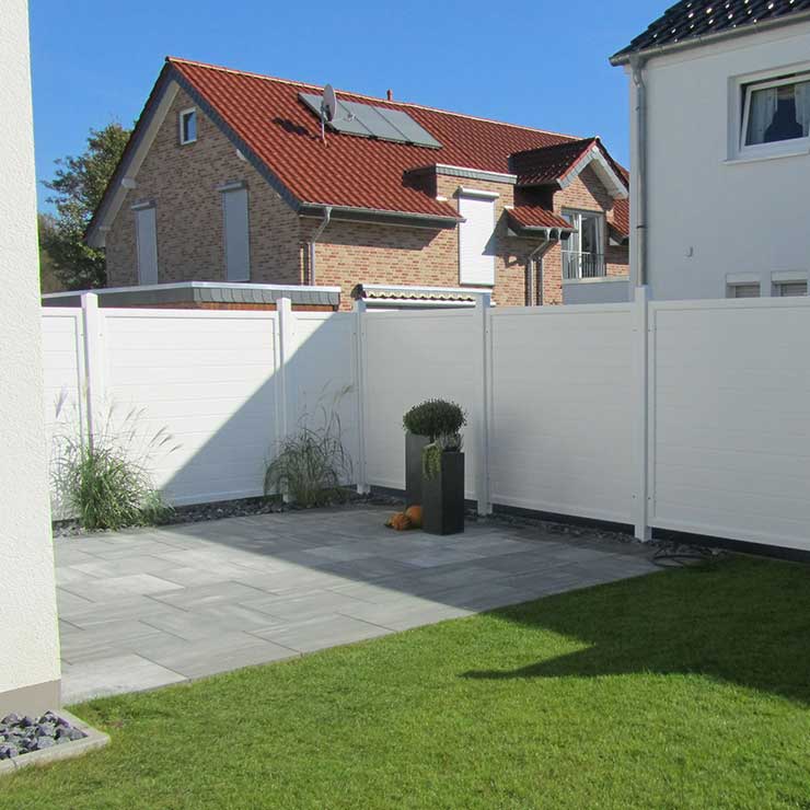 hoher Sichtschutzzaun in Weiss, auf einer Terrasse, in einem Wohngebiet