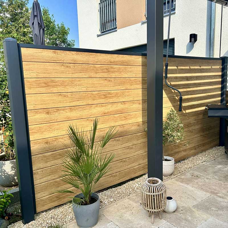 Sichtschutzzaun im Garten aus Kunststoff in der echten Holzoptik Astfichte