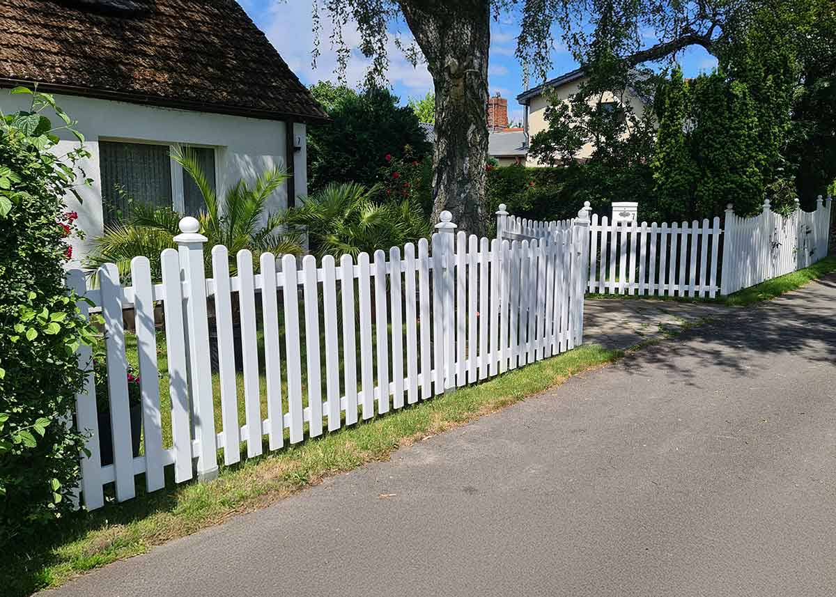 weißer Lattenzaun mit Unterbogen und Tor im Vorgarten aus Kunststoff