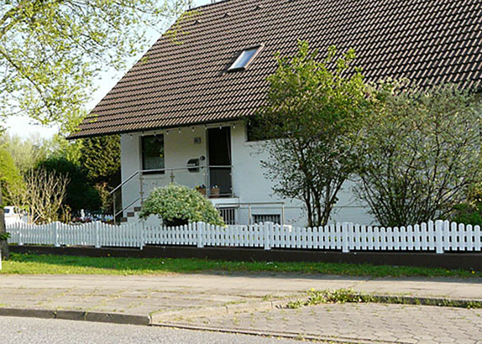weißer Lattenzaun mit Unterbogen im Vorgarten – robust, pflegeleicht, gut aussehend