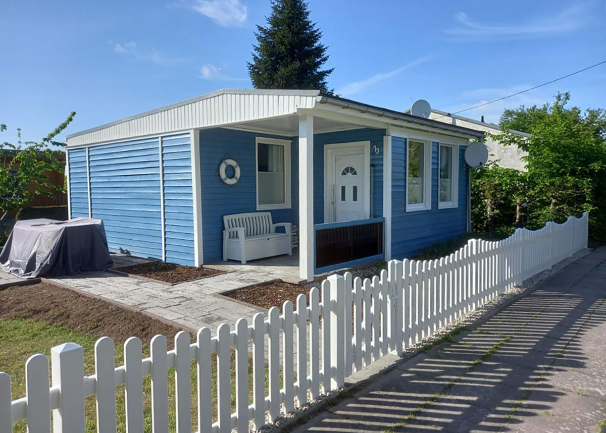 Lattenzaun Gartenzaun in Weiß aus hochwertigen Kunststoff mit Unterbogen passend zum maritimen Ferienhaus