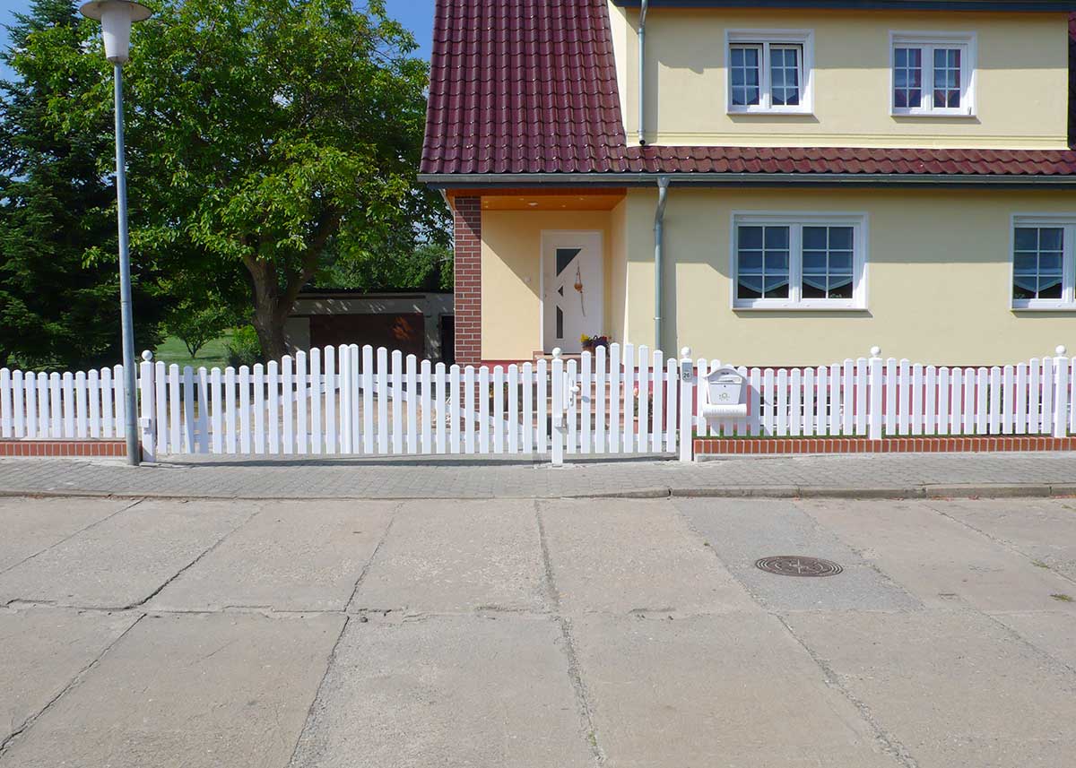 eleganter Friesenzaun in Weiß aus hochwertigen Kunststoff mit Bogen und Toranlage in der Einfahrt, Vorgarten