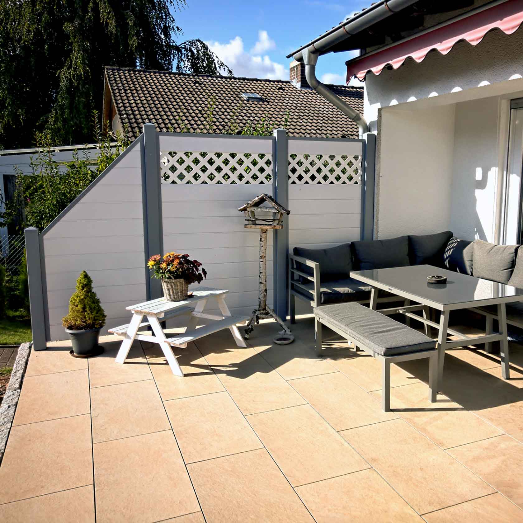 Windschutz an einer Terrasse in Weiß mit grauen Pfosten